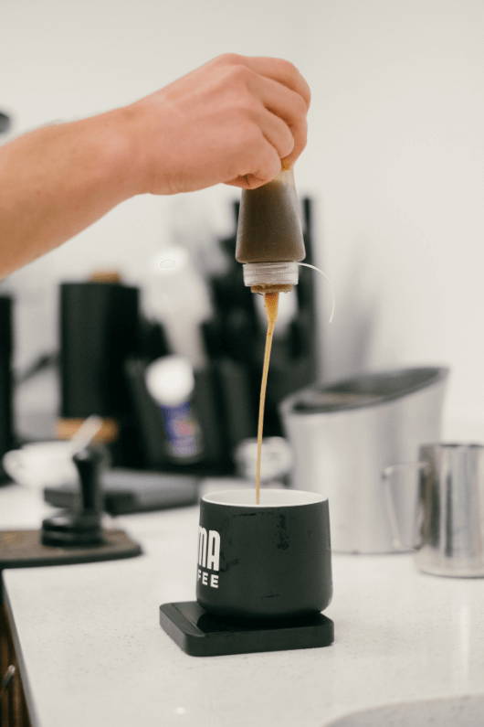 Chocolate syrup being added to a Mocha