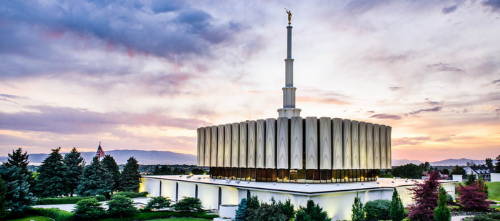 Provo Temple beneath a white, blue, and orange sky.