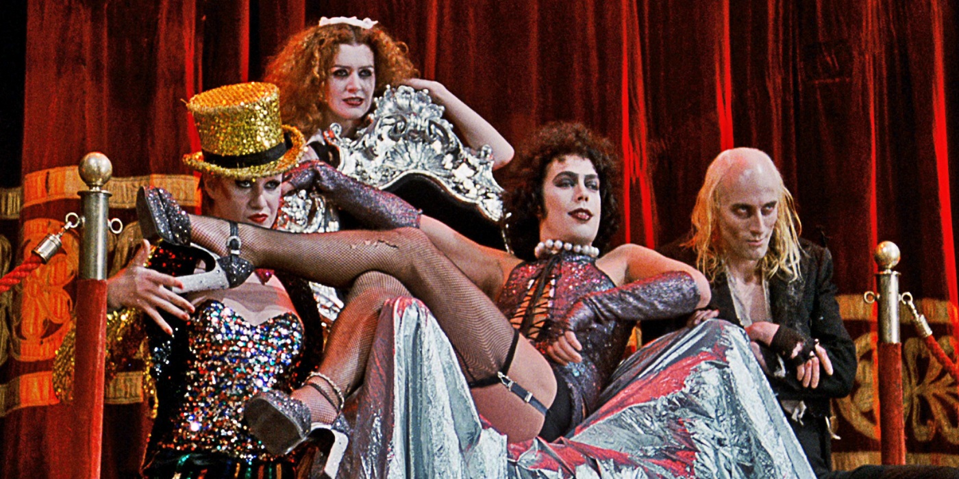 The cast of rocky horror dressed in their respective performing outfits all posing close together.