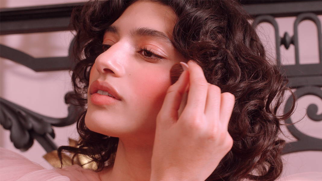 Femme applicant un blush Bourjois sur ses joues