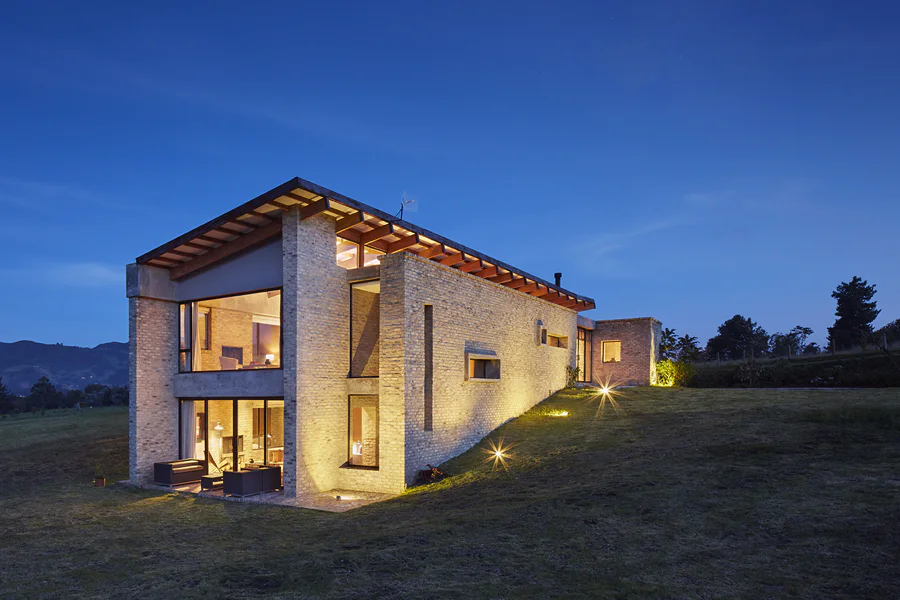 Casa UM – fachada iluminada al atardecer