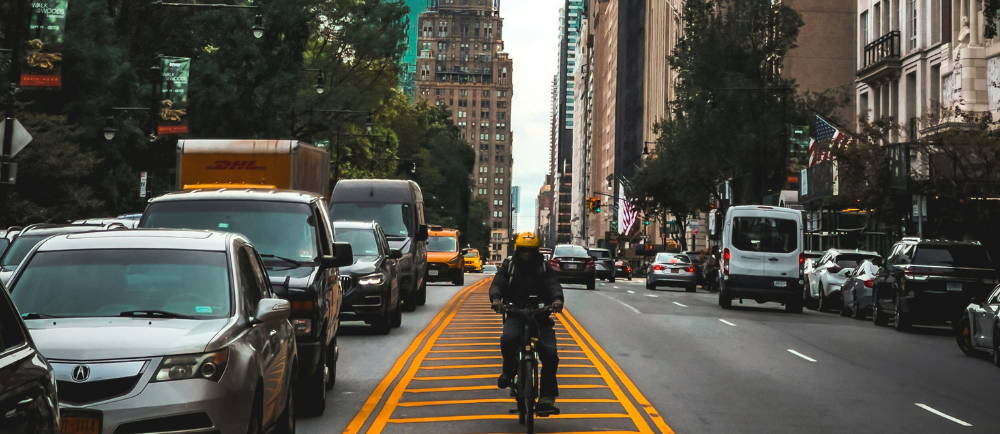 a person riding an electric bike toward the camera in New York City