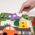 Hand moving a purple felt plane featured on a page of the Montessori Genius Giraffe Book for kids.