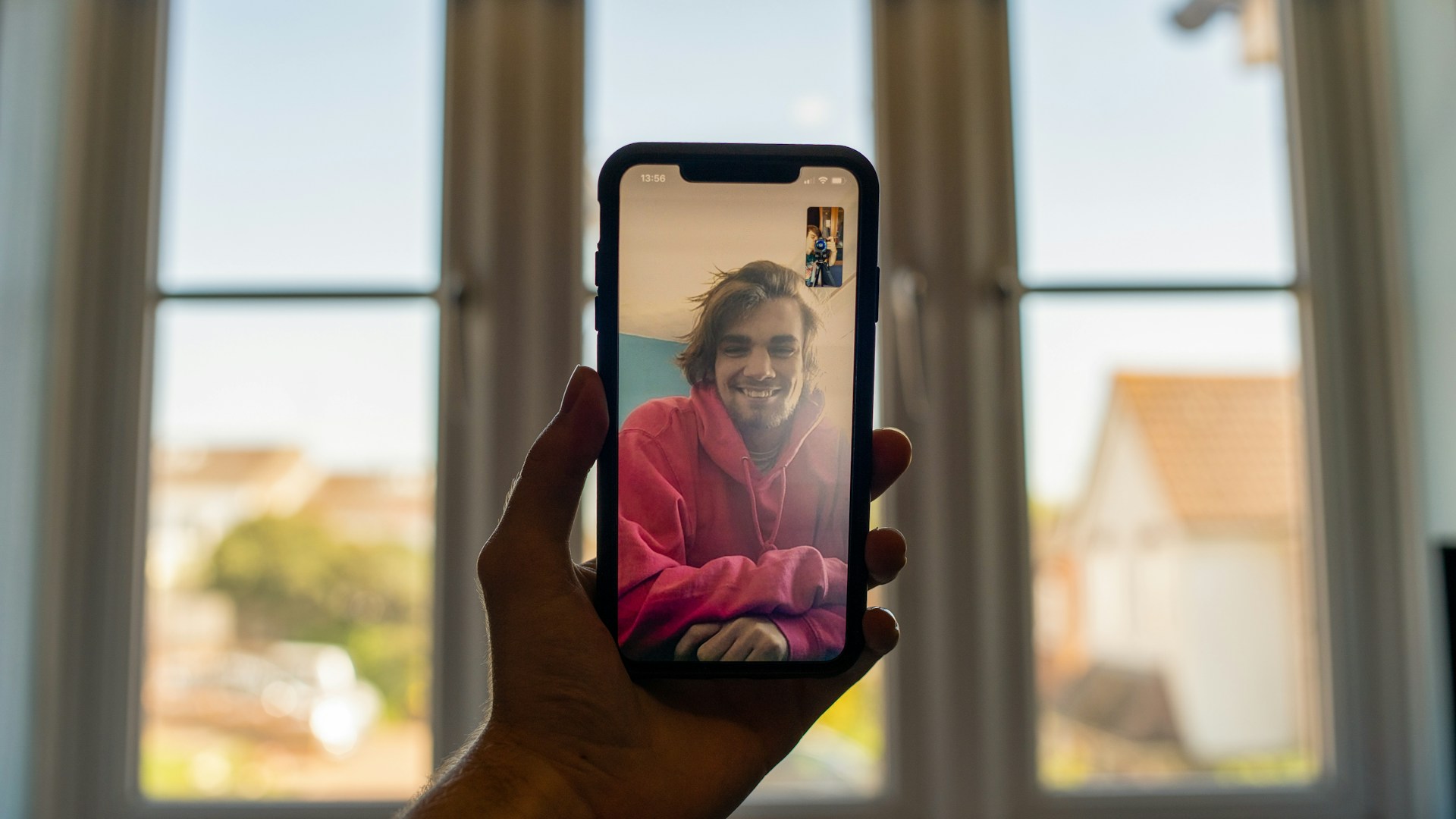 Someone holding up a smartphone during a video call with a friend or family member.
