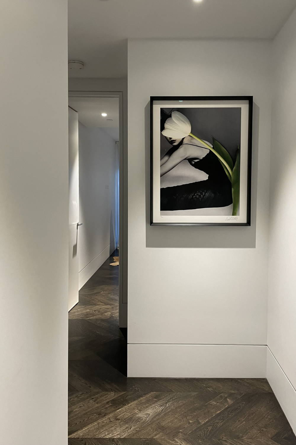 'Round & Round' - by Dina Broadhurst - A black and white photographic print embellished with a white tulip over a figure in a black dress