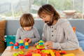 Parent and child using a board to build and sort colorful pieces while learning through hands-on play