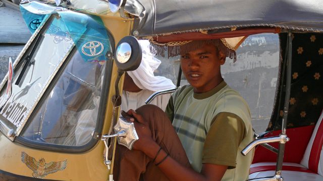 An unknown man and a motorcycle taxi driver near an unfamiliar passenger closeup in Wadi - Halfa, Sudan