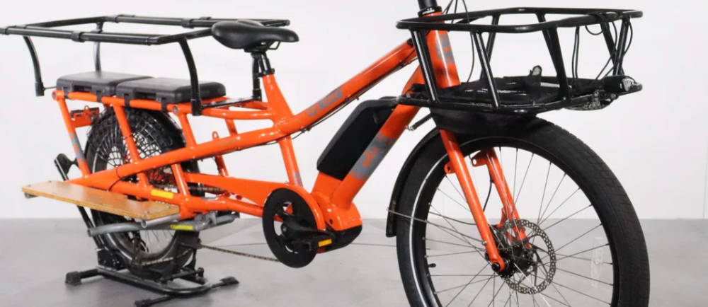 an orange Yuba Spicy Curry electric cargo bike