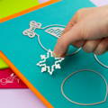A craft die being placed on blue cardstock
