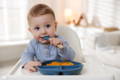 Baby putting a decoration on a birthday cake.