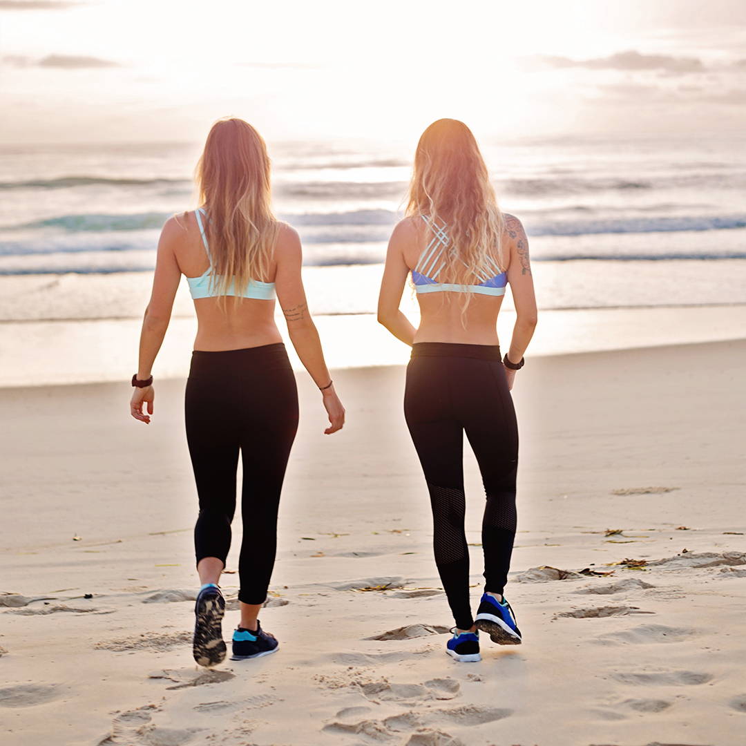 two girls walking on a beach
