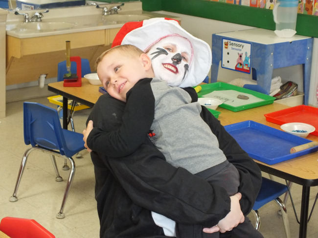 A little boy hugs a woman dressed as Dr. Seuss's Cat in the Hat 