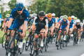 Group of competitive cyclers riding on the road, coming head on.