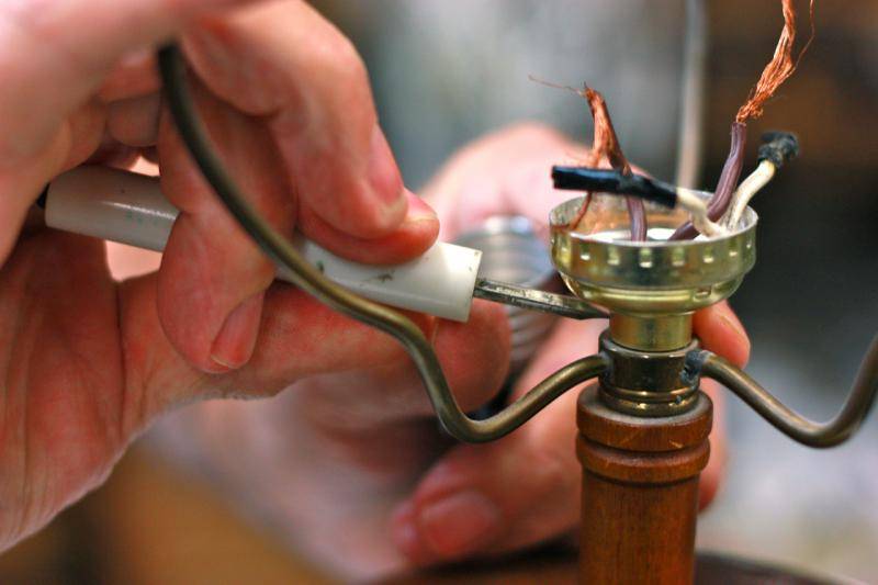 picture of man repairing a broken lamp.