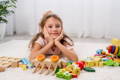 Little girl in the living room surrounded by Montessori toys.