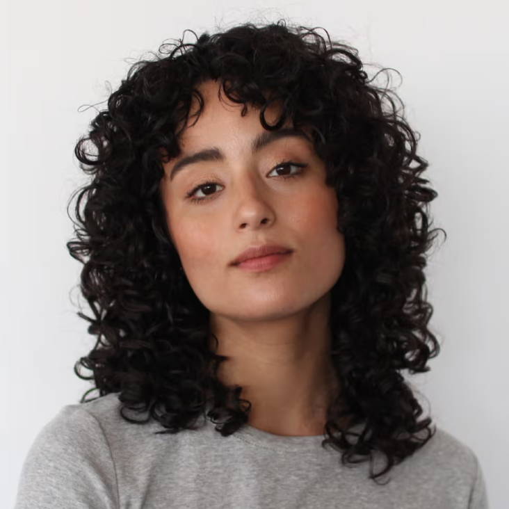 woman with dark curly hair in a shag haircut