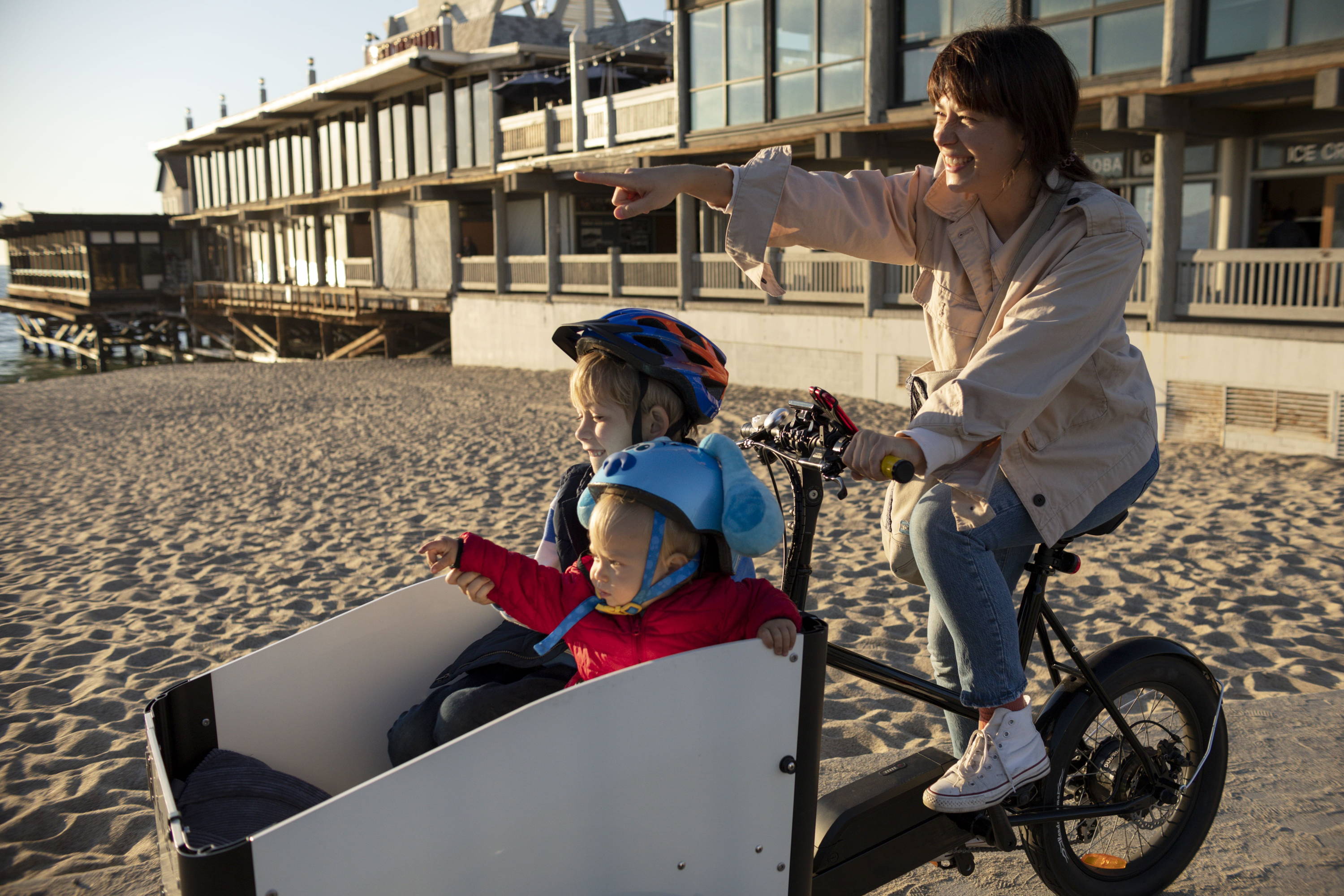 Een gezinsuitstapje op een elektrische bakfiets voor een moeder en haar twee kinderen.