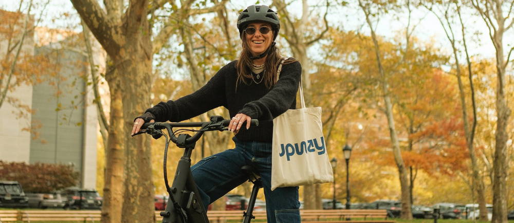 a woman riding a step through electric bike in new york city during autumn
