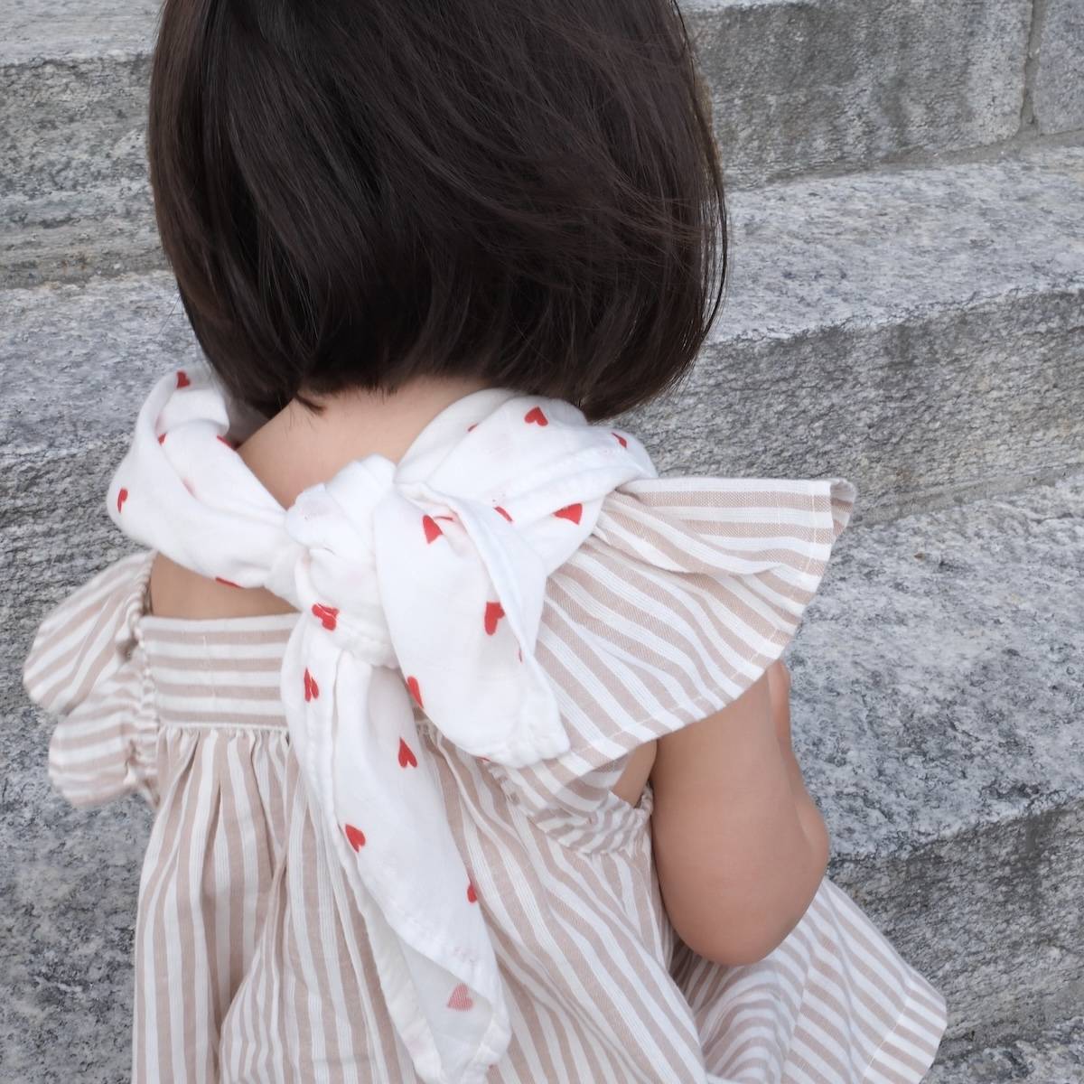 gigoteuse réversible fraises blanc rouge fruit élégant de la marque suisse Joli Nous, un accessoire premium pour bébé, alliant design raffiné et qualité exceptionnelle ajustable