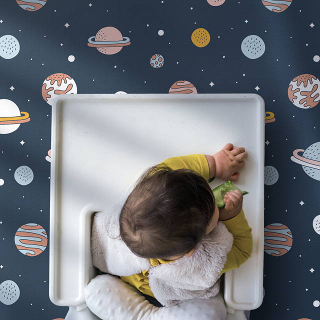 Messy eater toddler in high chair with splat mat