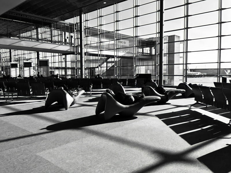 Vue artistique en noir et blanc du terminal de l'aéroport Charles de Gaulle, montrant sa grande verrière et son architecture moderne