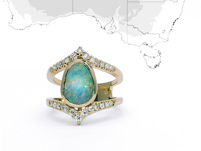 Opale d'Australie sertie sur une bague princesse avec une vingtaine de petits diamants ancrés sur le corps de bague en or jaune.