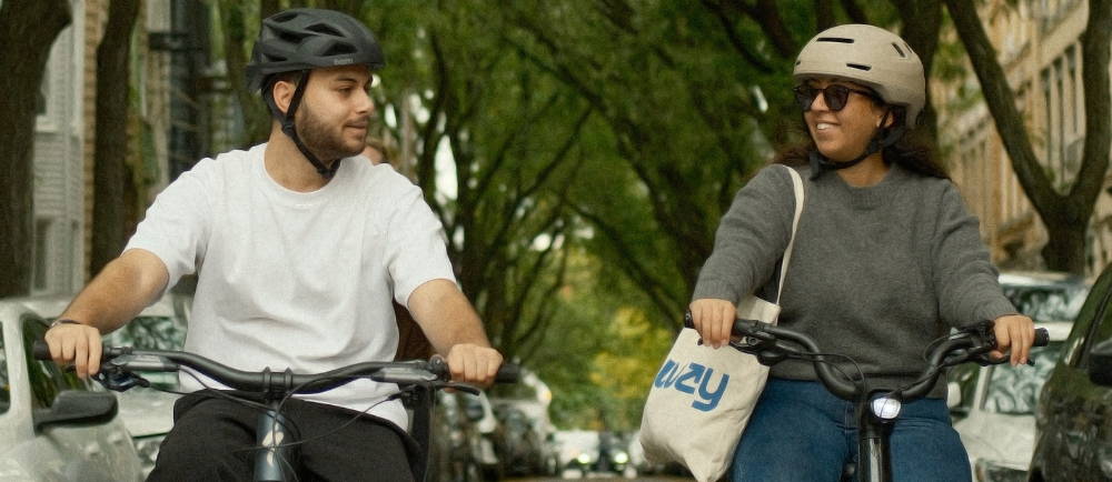Two riders wearing helmets commuting on Upway electric bikes
