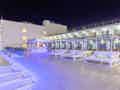 Großzügige Hotelterrasse bei Nacht mit beleuchteten Stufen, Lounge-Betten und einer modernen Bar.