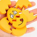 Close up on a hand holding puzzles from the Montessori Funny Egg Faces set. 