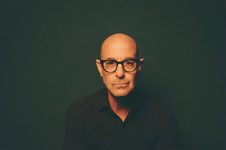 Image may contain: Stanley Tucci, Face, Head, Person, Photography, Portrait, Body Part, Finger, Hand, and Sitting
