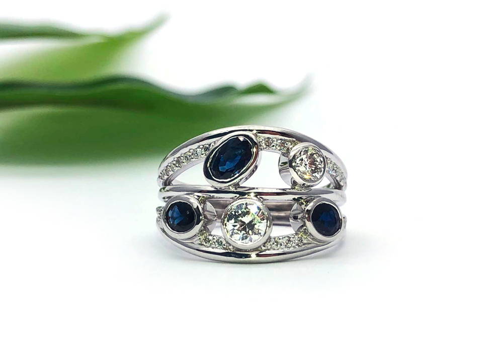 White gold ring with ring body stepped by wires that meet at the back with 2 diamonds and 3 sapphires at the front