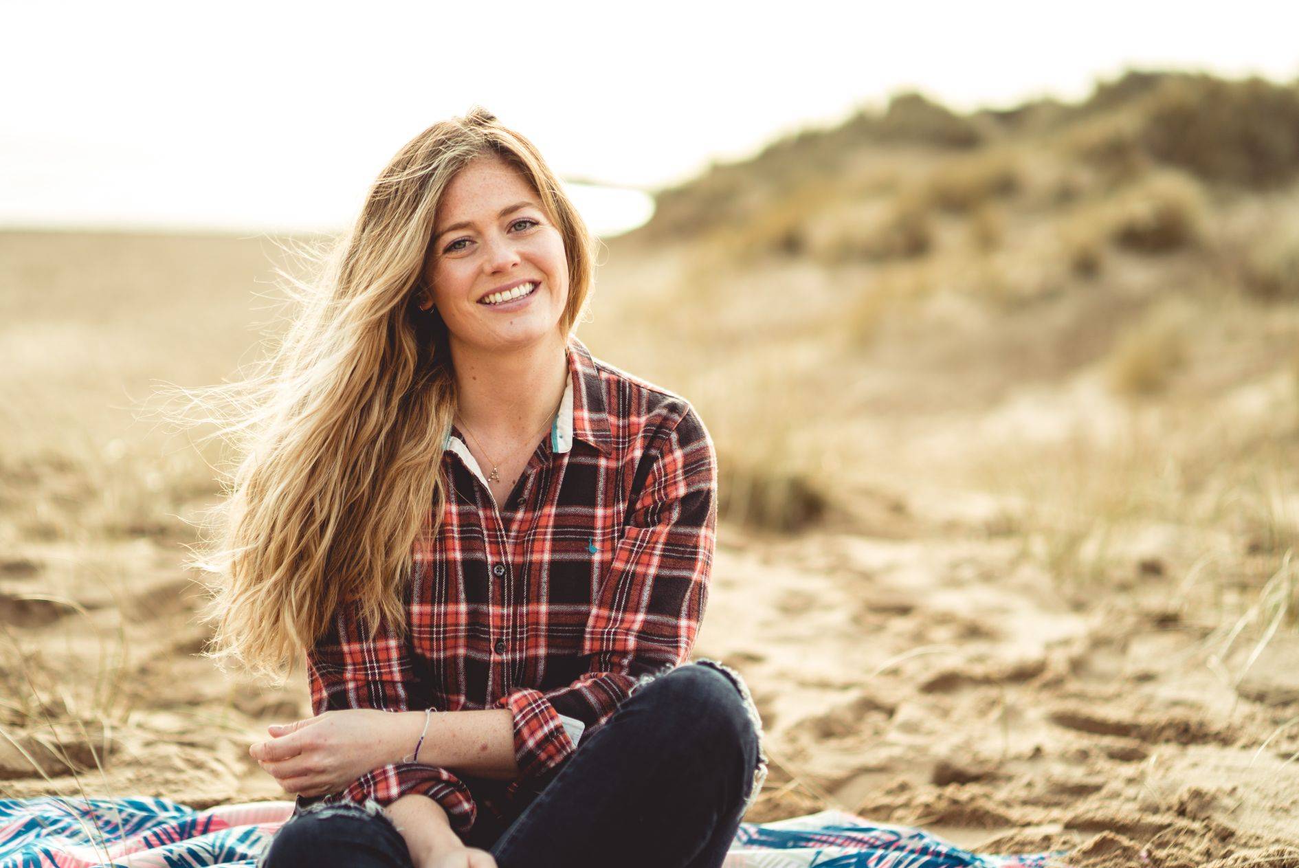 Image of abi sitting on beach with natural wavy hair