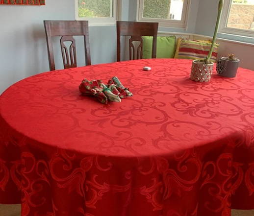 red frederic damask tablecloth on an oval table