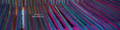 Logo tisserand indépendant de Harris Tweed Donald MacDonald avec des fils filés de Harris Tweed mauve rose et bleu prêts à être tissés sur un métier à tisser