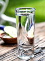 blanco tequila shot with a slice of apple in the background