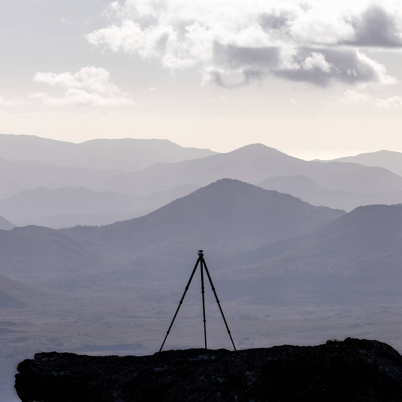 Silhouette of my tripod against an expansive shot of the Crossing River Valley. Taken from atop the Western Arthurs in Tasmania Australia