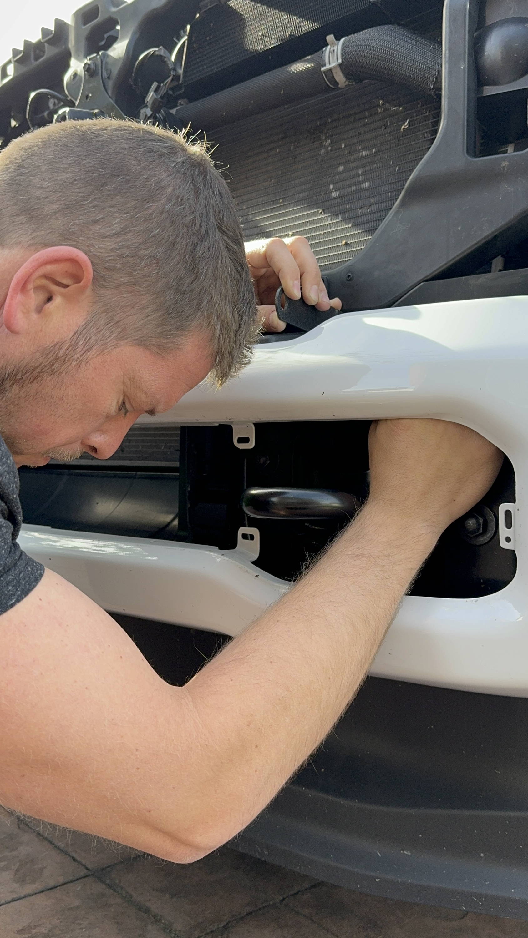 mike owner of m&R automotive tightens metal brackets for ford superduty off road light bar