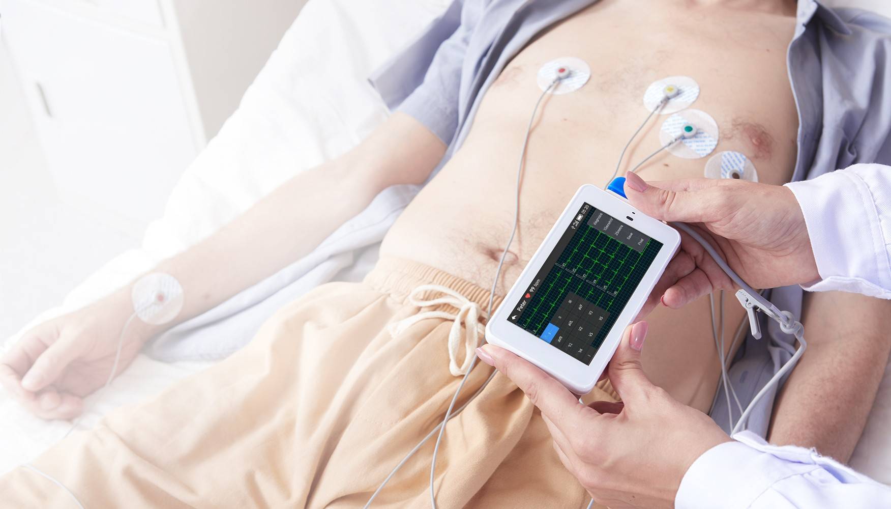 يستخدم الطبيب جهاز تخطيط القلب الجيبي ذي 12 سلكًا لإجراء اختبار للمريض