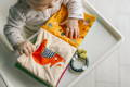 Baby exploring a colourful fabric sensory book featuring a fox.