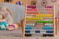 Wooden abacus on a carpet in a cute playroom.