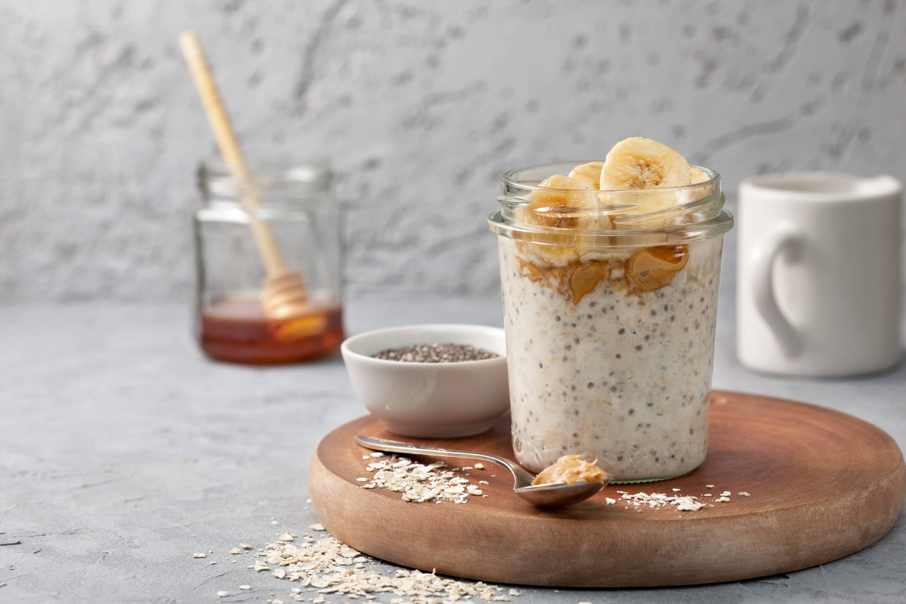 Healthy overnight oats in a glass jar with milk, honey, chia seeds and bananas to help build collagen