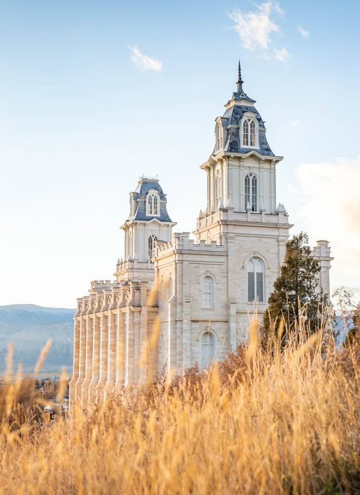 Vertical photo of the Manti LDS Temple standing in a wheat field.