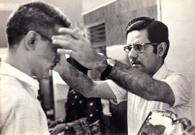 Our founder, Shri R.K. Kataria, fitting a client's spectacles