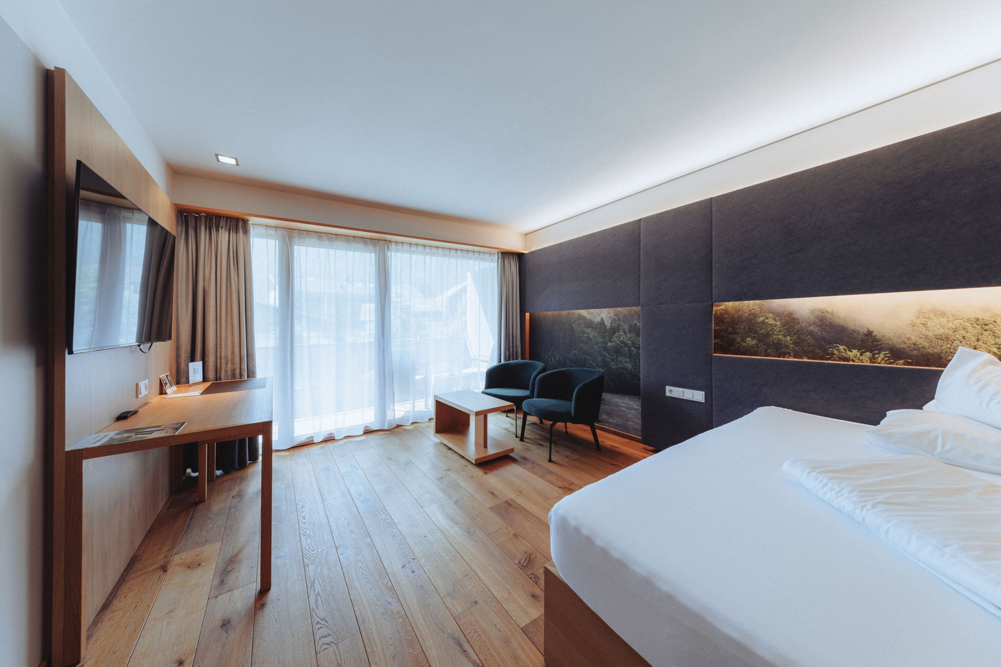 Zimmer Kanisfluh im Hotel Sonne Mellau mit Wohnbereich und großen Fenstern