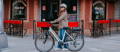 Woman with Gazelle Medeo electric city bike in front of bar