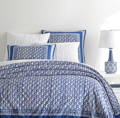 Image is of a queen bed with indigo blue linens.