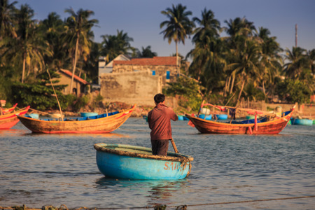 Vietnamese fisherman in round fishing boat.jpg