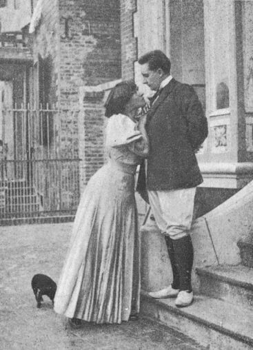 Colette leaning onto Henry who is standing on some steps. They are looking at eachother's eyes.