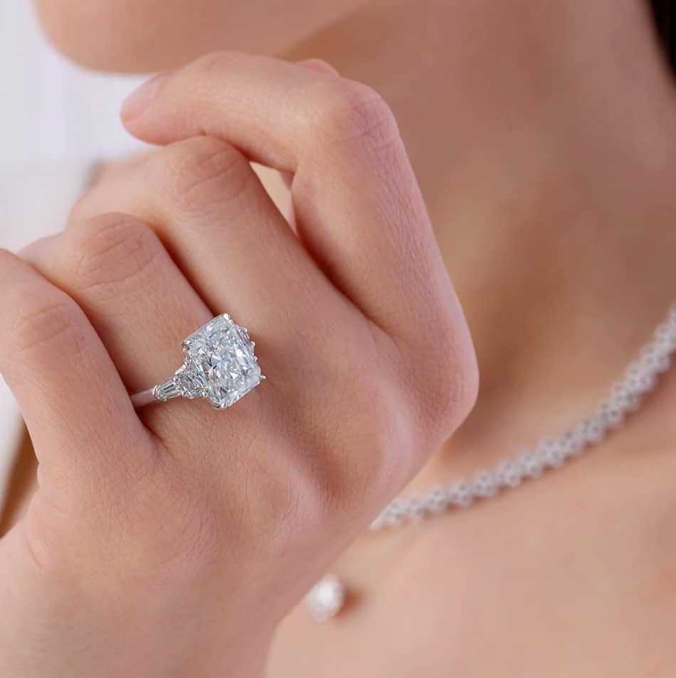Model posing with a Kwiat radiant diamond engagement ring. 