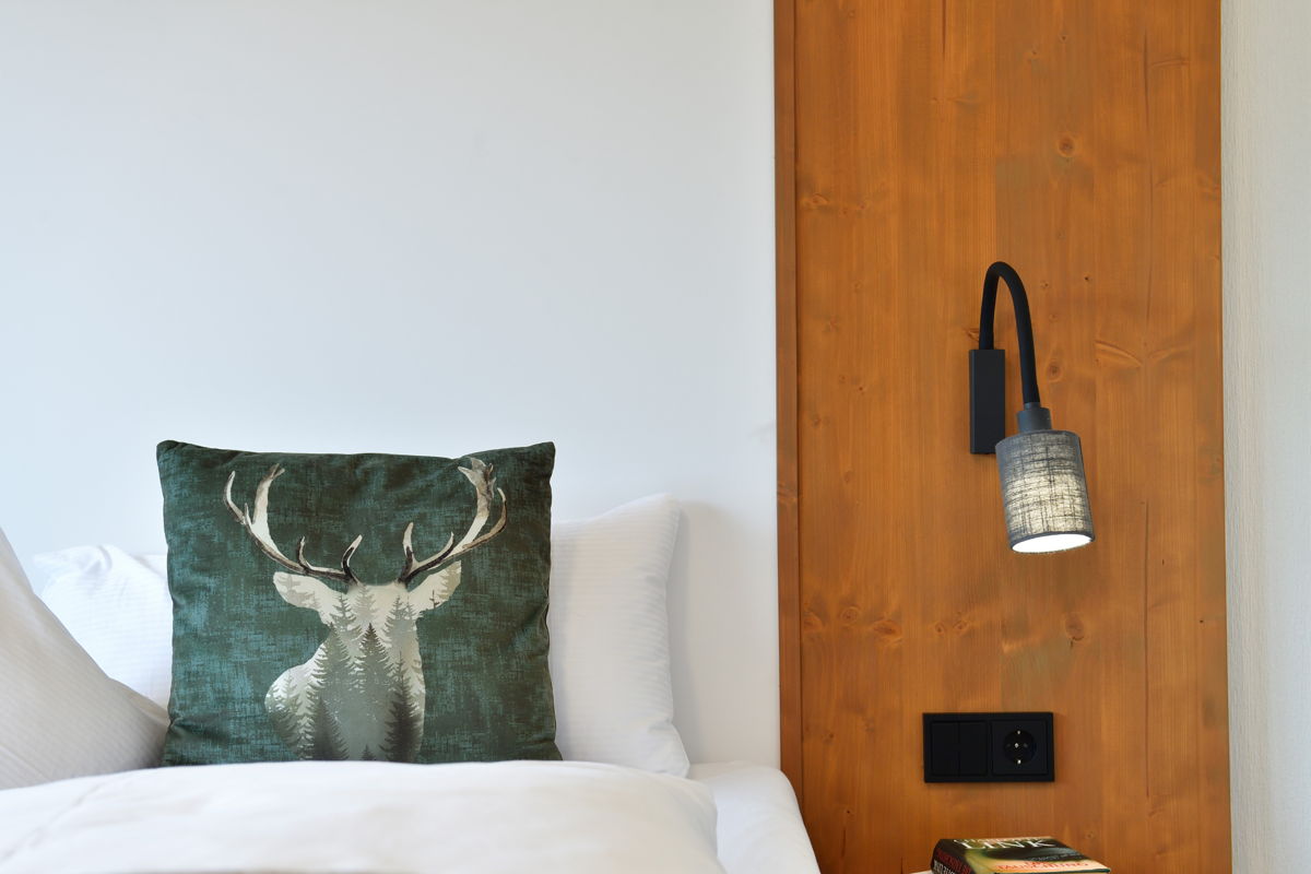 Stilvolles Schlafzimmer - Bett mit alpinem Dekokissen in der Ferienwohnung